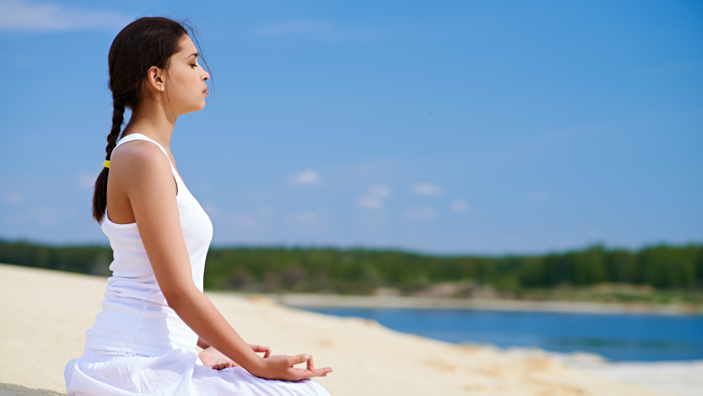 A tranquil outdoor scene of a person engaging in various stress relief activities. In the foreground, a person is practicing yoga or meditation, with calm and composed body language. In the middle ground, the person is reading a book or writing in a journal, accompanied by a cup of tea. In the background, a soothing natural landscape with rolling hills, a serene lake, and wispy clouds in a soft, pastel-colored sky. The lighting is warm and diffused, creating a calming, therapeutic atmosphere. The overall mood is one of serenity, mindfulness, and a sense of rejuvenation.